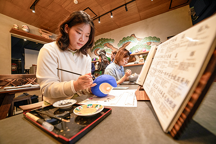 專注地用毛筆描繪設計圖的情景