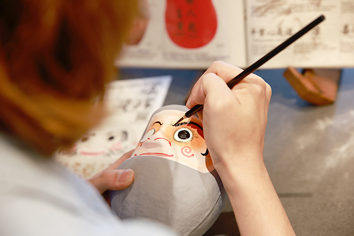 專注地用毛筆描繪設計圖的情景